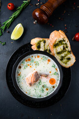 Finnish cuisine fish soup with salmon, cream, potatoes, dill and bread with sauce and spices.