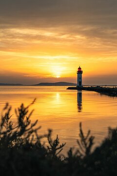 Vertical shot of the Les Onglous lighthouse in Marseillan, Herault, France during sunset