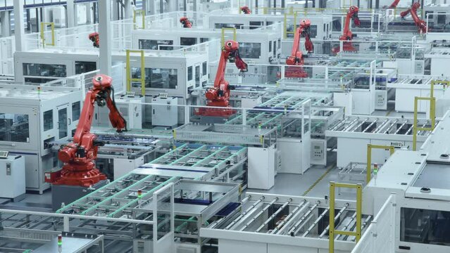 Time-lapse video of Automated Solar Panel Production Line with Orange Industrial Robot Arms. Looped video. Modern, Bright Manufacturing Facility.