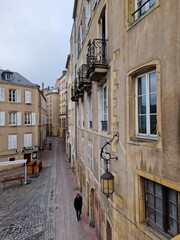 Young man walking alone alongside walls in Metz