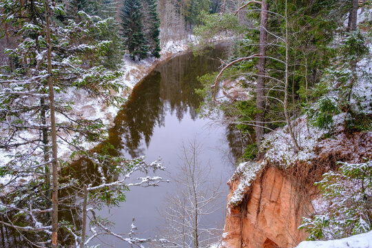 The river Salaca is meandered by high sandstone cliffs. Skanaiskalns nature park. November is the first snow in Mazsalaca in Latvia.