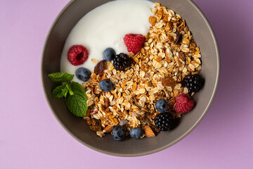 Breakfast granola with berry in bowl food on purple surface - Powered by Adobe