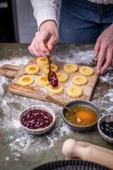 Weihnachten Plätzchen backen, Weihnachtsbäckerei, frisch gebackene Plätzchen mit verschiedenen Marmeladen füllen, Spitzbuben Plätzchen