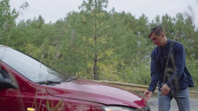 Breakdown of ato during travel. a man raises his hood on the road. Nervous guy during a vacation trip. High quality 4k footage