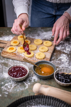 Weihnachten Pl&auml;tzchen backen, Weihnachtsb&auml;ckerei, frisch gebackene Pl&auml;tzchen mit verschiedenen Marmeladen f&uuml;llen, Spitzbuben Pl&auml;tzchen