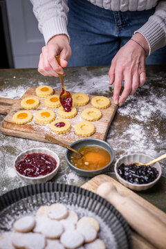 Weihnachten Pl&auml;tzchen backen, Weihnachtsb&auml;ckerei, frisch gebackene Pl&auml;tzchen mit verschiedenen Marmeladen f&uuml;llen, Spitzbuben Pl&auml;tzchen