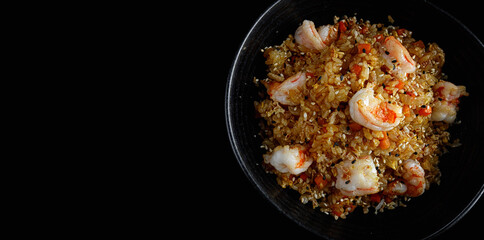 Fried rice with shrimp and sesame, on a dark background