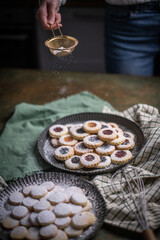 Weihnachten Plätzchen backen, Weihnachtsbäckerei, frisch gebackene Plätzchen mit Puderzucker bestreuen