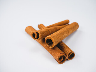 Cinnamon sticks lie isolated on a white background. Spicy cinnamon has a brown color and is used as a seasoning for cooking various foods.