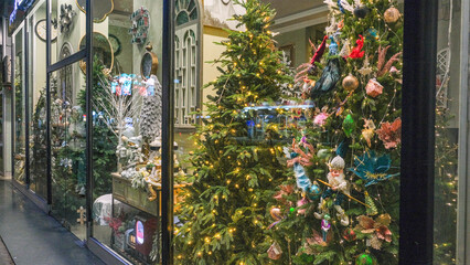 Christmas shop window decorated with christmas gift Beautiful festive Christmas storefront with decorated artificial Christmas trees and toys