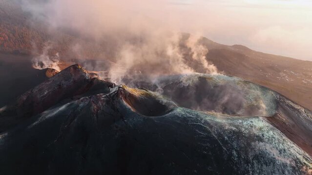 Aerial view of Volcano at Cumbre Vieja, La Palma at sunset with white and black smoke plumes and ashes in the Canary Islands