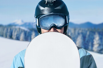 Close up Portrait of snowboarder in Carpathian Mountains, Bukovel Snowboarder. A mountain range reflected in the ski mask. wearing ski glasses