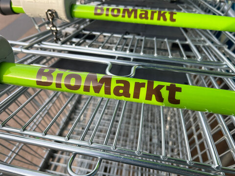 Hamburg, Germany - November 15, 2022: Handle of a shopping cart with the logo of BioMarkt , Biomarkt, Dennree GmbH in Hamburg, Germany - Supermarket for organic products