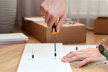 Furniture assembly. Closeup of workers hand with professional tools and furniture details