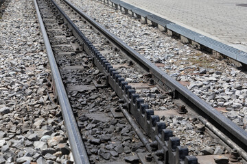 Diagonal view of railway tracks with a third cog wheel track in the middle. Typical of railway...