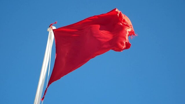 Red warning flag on the sea beach at the lifeguards. Storm on the sea