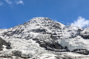 Fototapeta premium The Jungfrau mountain peak in Switzerland with glaciers and pack ice covering parts of the peak. 