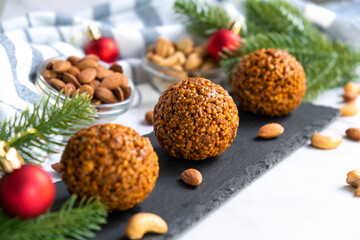 Christmas nut balls cookie on black slate board with almond and cashew. Simple homemade cookie with nuts. Recipe of dessert for New Year and Christmas holidays menu.