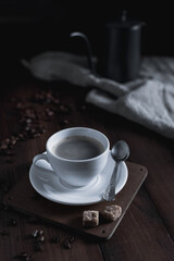 Cup of coffee and kettle beans at wood table