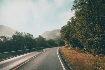 Fototapeta premium A road in Norway surrounded by trees and mountains