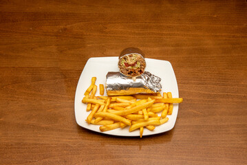 Typical durum rolled with aluminum foil stuffed with lamb meat and lettuce along with a portion of...