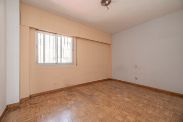 Empty room with smooth white painted walls, wrought iron radiators with radiator covers with aluminum windows and white doors