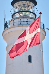 Danish Dannebrog in front of Hirtshals lighthouse. High quality photo - obrazy, fototapety, plakaty