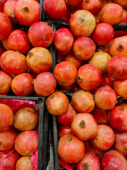 Fototapeta na wymiar ripe red pomegranate fruits in plastic boxes on the supermarket counter