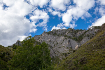 Obraz premium A large mountain with a sheer cliff close-up against the sky. Hiking tourism. Mountains of the Altai Mountains, Altai Republic