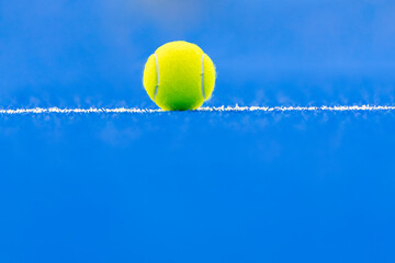 Paddle tennis and tennis ball on blue court.  Horizontal sport poster, greeting cards, headers, website