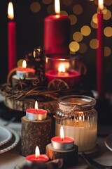 Rustic table decor for Christmas or New Year family dinner. Centrepiece with red candle, dry orange, cone, cinnamon, anise. Zero waste eco-friendly home. Cozy atmosphere, dark background. Close up