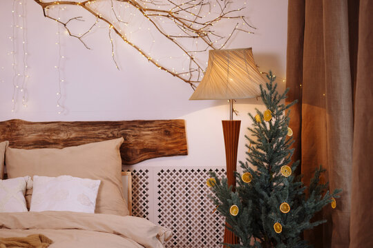 Beautiful Decorated Christmas Tree With Fairy Lights In Bedroom Interior