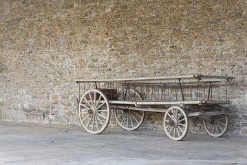 Un vieux chariot en bois sous une grange. Une vieille charrette en bois dans une ferme. - obrazy, fototapety, plakaty