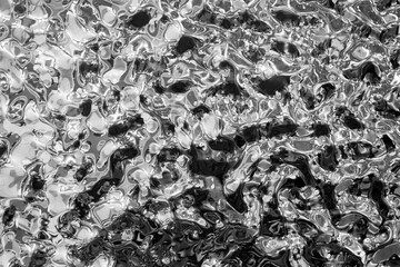 Background of molten metal, liquid steel close-up. Liquid metal texture, shiny reflective surface,...