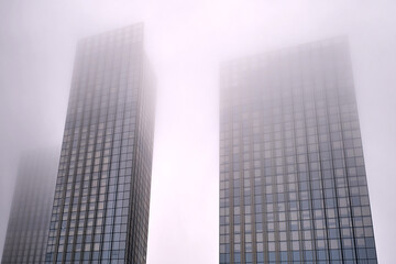 Obraz premium Windows of skyscrapers in the fog, background copy space. Metal structures with windows of a high-rise building in smog, close-up