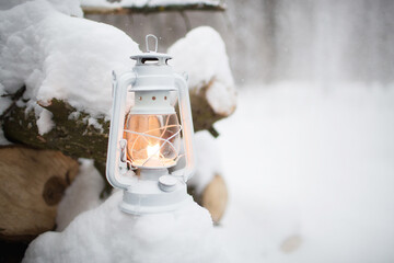 Winter landscape. Cold season. Kerosene lamp or lantern on a snow-white snowy background with...