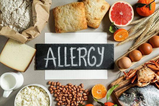 Allergy food concept. allergene - milk, fish, strawberry, bread, eggs, peanuts, citrus, wheat flower and others on grey backgrond