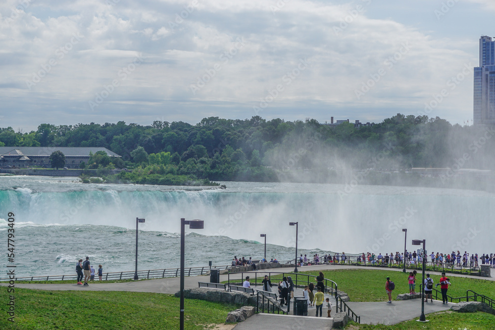 Wall mural Niagara Falls, NY: Tourists view the Horseshoe Falls from Prospect Point, on the American side of the Niagara Gorge, across from Table Rock in Canada.