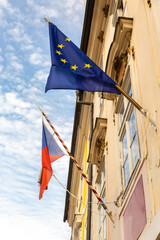 EU and Czech flag on a building against the sky. 