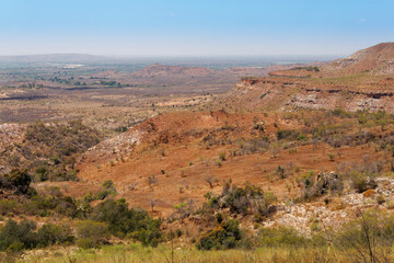 Landscape of Madagascar, typical scenery of the Malagasy countryside with the rice fields, hills and valleys, small simple houses and dry meadows. Devastated environment with great erosion