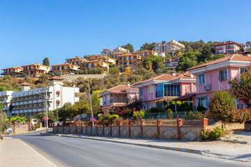 Fototapeta premium Street in Residential Neighborhood with homes and flowers. Kusadasi, Turkey. Sunny Morning.