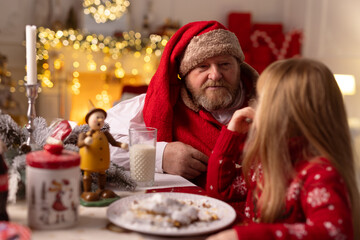 cheerful santa sits in the house at the table, christmas concept
