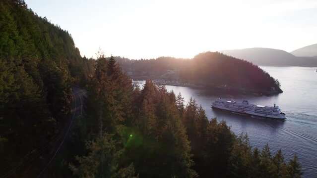Car ferry boat sailing into dock in scenic bay surrounded by mountains, sun rays ocean, tranquil scene, Horseshoe Bay ferry terminal. 24FPS 4K PRORES 422