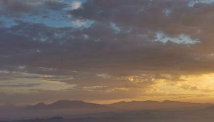Montagne tra nebbia nuvole e sole