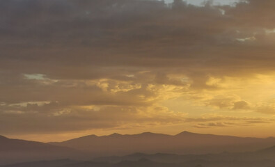 Montagne tra nebbia nuvole e sole