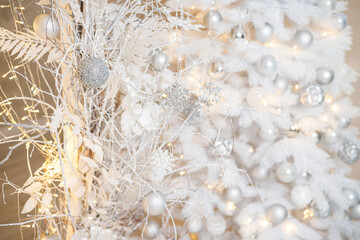 A white Christmas tree is decorated with silver plastic toys. Bright festive decoration for the new year