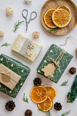 Merry Christmas and Happy New Year on white background. Holidays greeting card. Christmas decoration with wrapping gifts,dried oranges and gift labels. Selective focus.