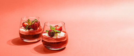 Italian dessert panna cotta in glass with strawberries. Healthy sweet food, hard light, dark shadow