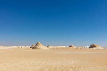 Fototapeta na wymiar Dramatic White Desert landscape with a blue sky background.
