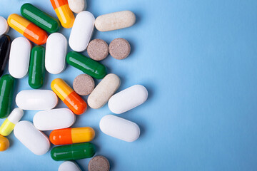 Top view of different pills on blue background,copy space for text.